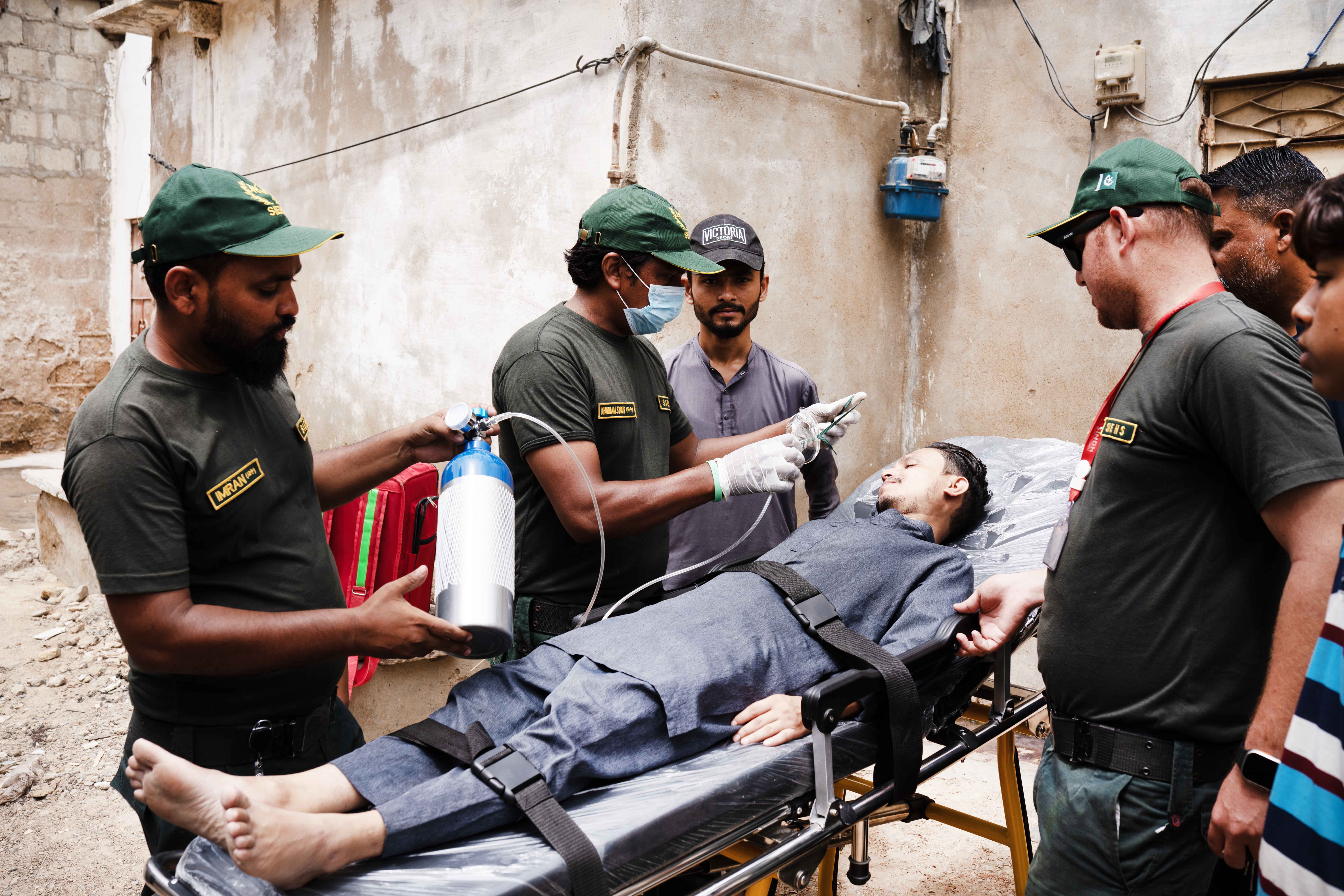 SIEHS 1122 crew giving oxygen to a patient on a stretcher in Karachi
