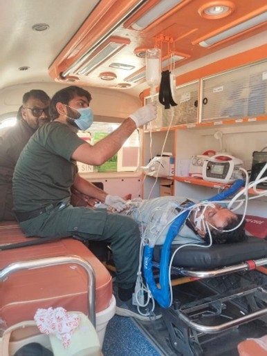 SIEHS paramedic adjusting an IV drip for a patient on a stretcher connected to monitoring equipment inside an SIEHS ambulance