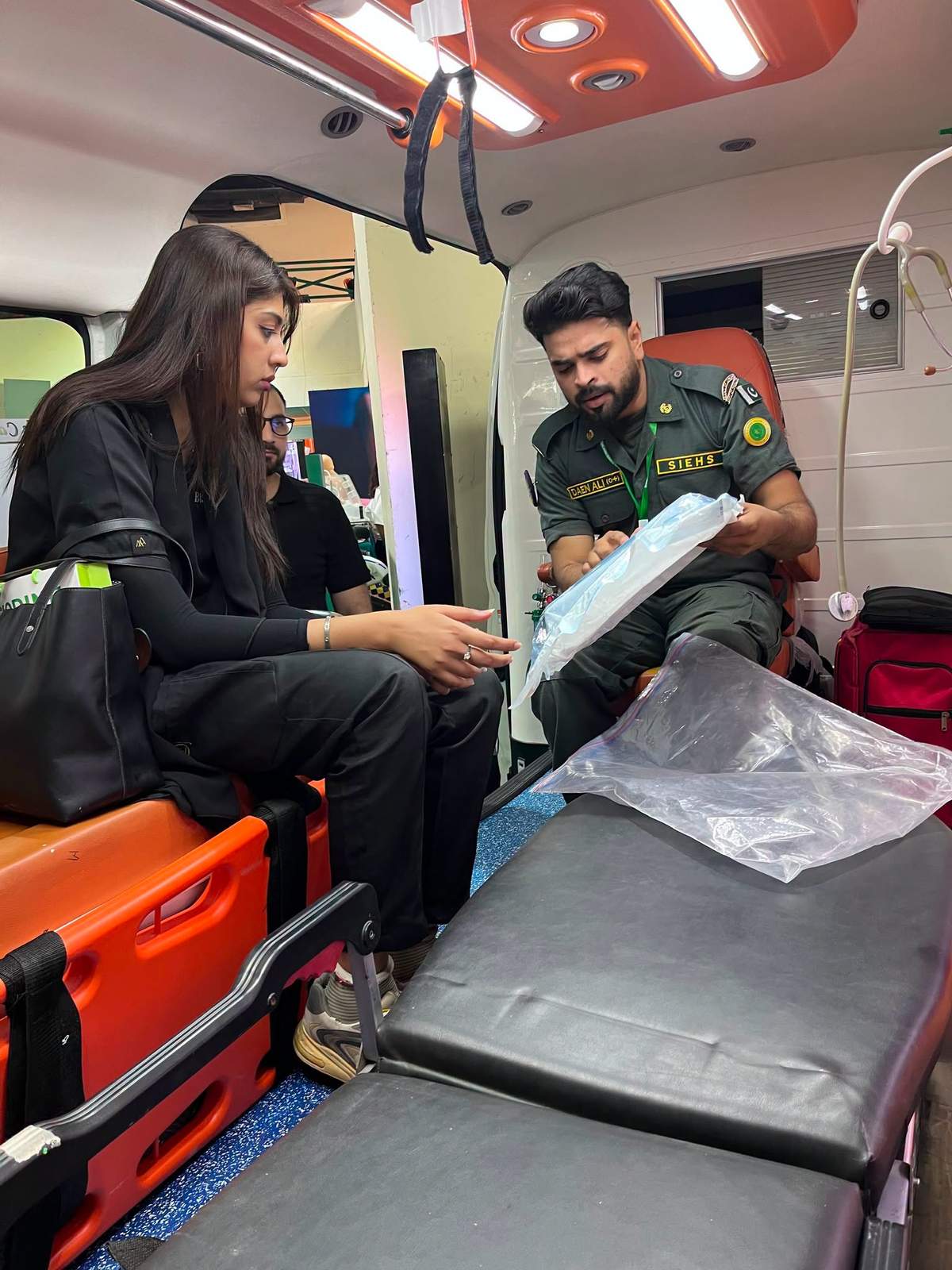 Visitors sitting inside a SIEHS free ambulance during a walkthrough at Health Asia 2026 in Karachi