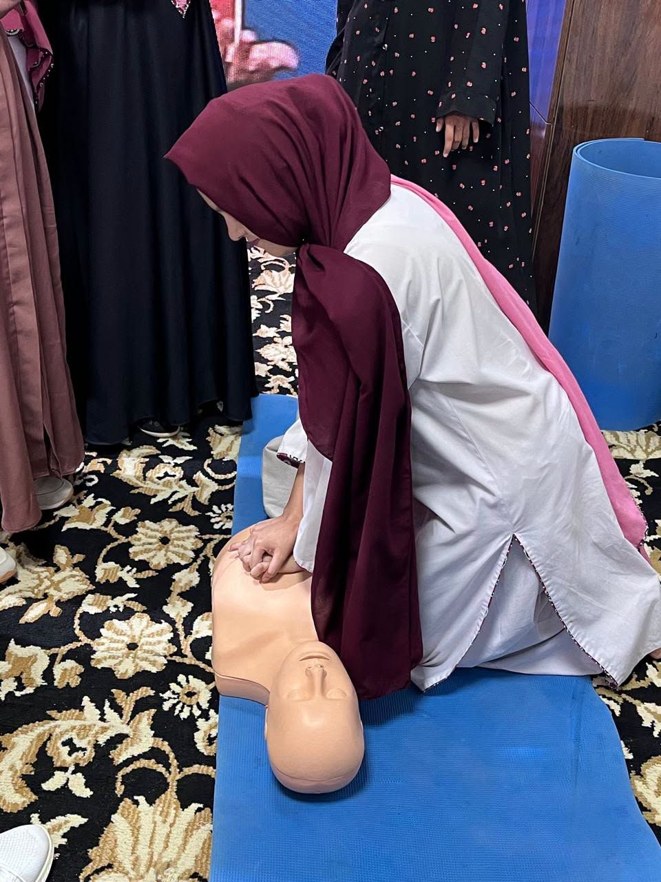 Woman practising CPR chest compressions on a training manikin at the SIEHS Health Asia 2026 booth