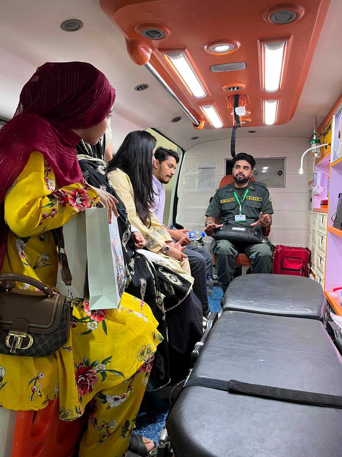 Visitors seated inside the SIEHS ICU-on-wheels ambulance being briefed by a paramedic at Health Asia 2026