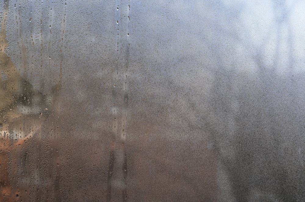 Steam and water droplets on a glass shower screen