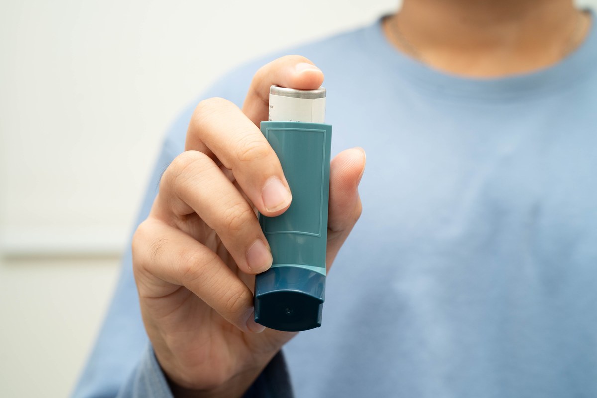 Hand holding an asthma rescue inhaler