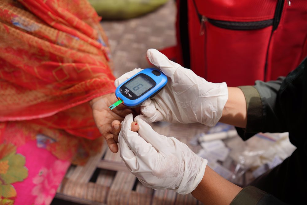 SIEHS paramedic testing blood glucose from a finger prick with a glucometer during a home visit