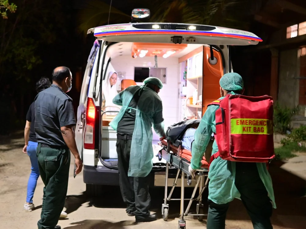 SIEHS 1122 paramedics loading a patient on a stretcher into an ambulance at night